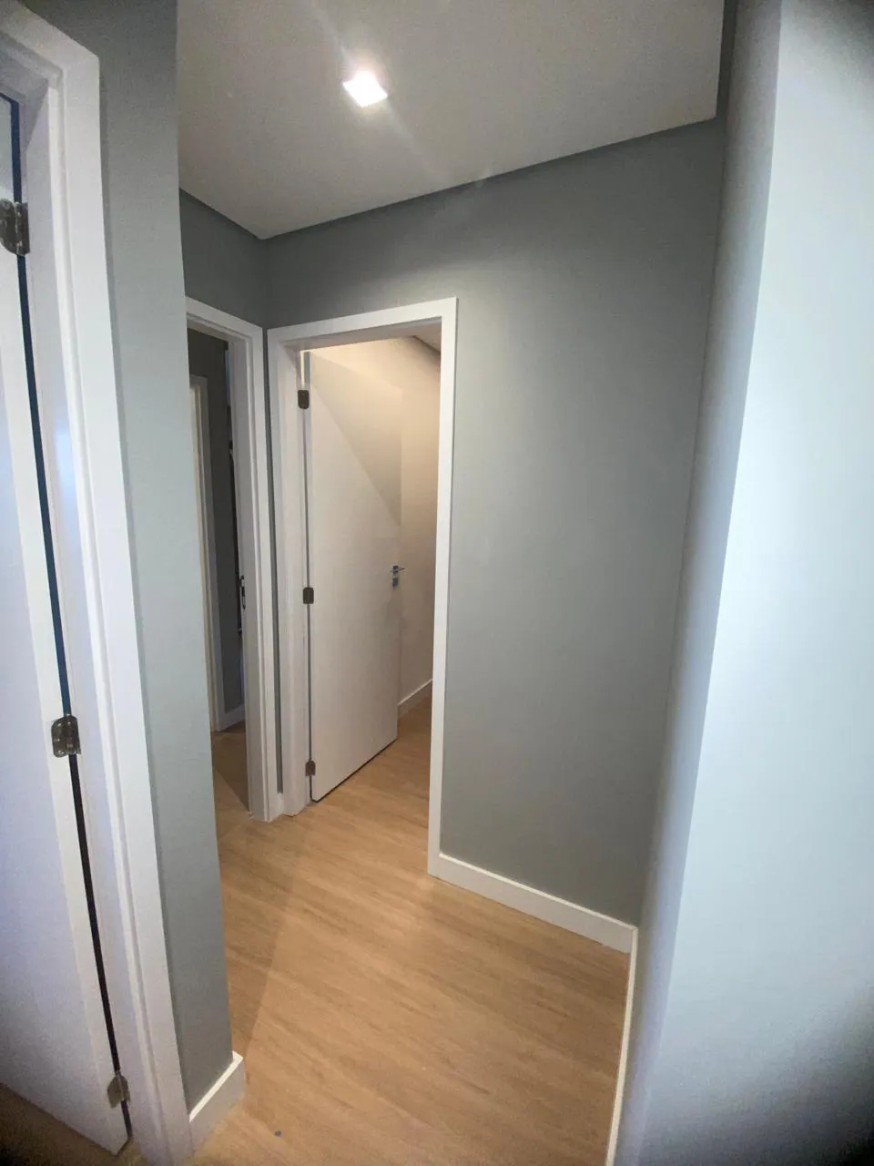 Corredor de apartamento com pintura cinza e arestas definidas