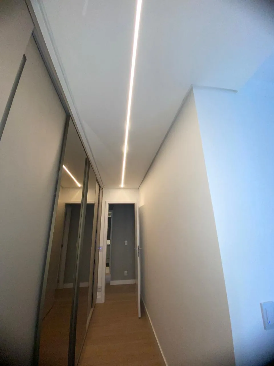 Corredor de apartamento com paredes niveladas e pintura branca