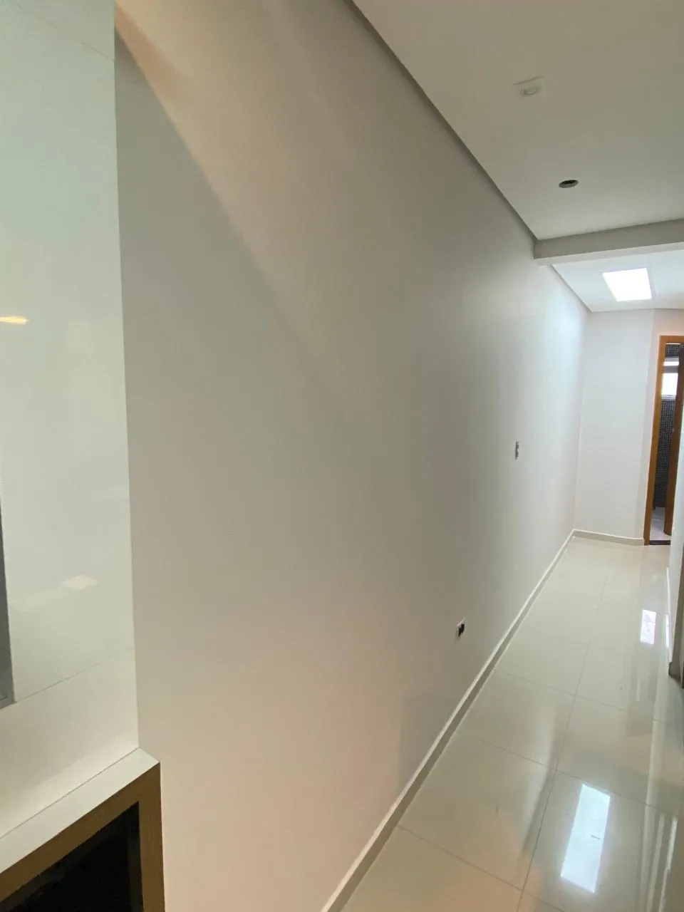Corredor residencial com acabamento liso após massa corrida