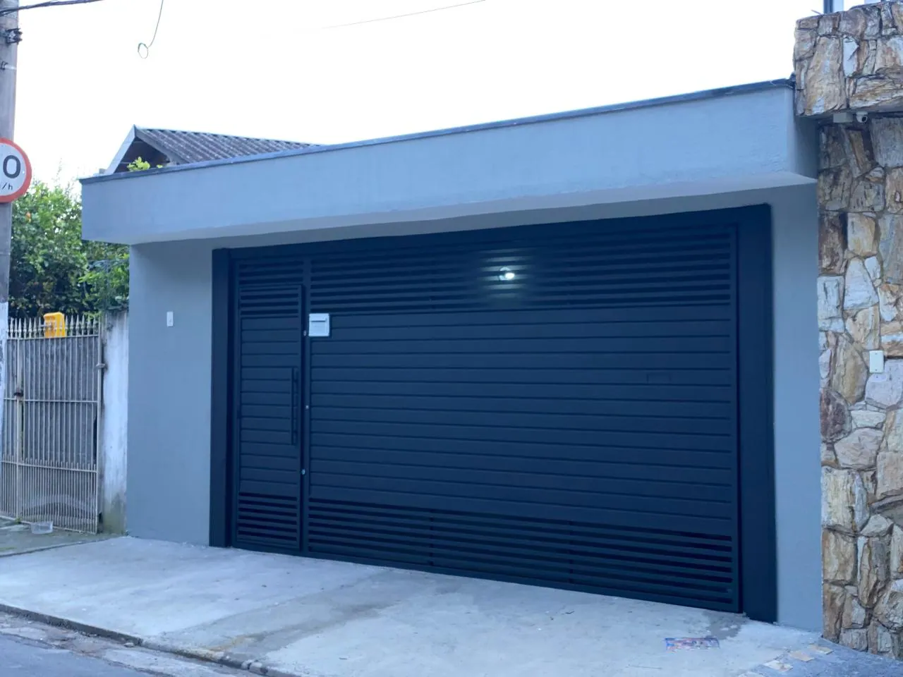 Fachada com portão azul e pintura externa renovada