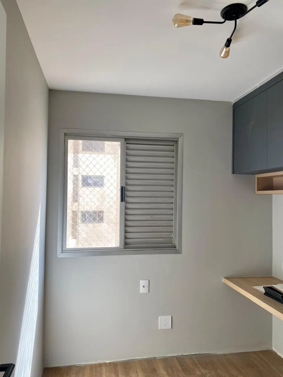 Quarto com pintura cinza harmonizada com móveis planejados